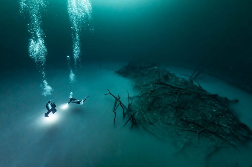 deux plongeurs survolant le cénote angelita à tulum deux plongeurs survolant le cénote angelita à tulum