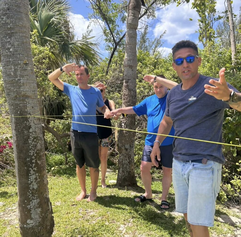 Instructeur enseignant à trois élèves autour d'une ligne de vie lors d'une formation en cénote dans la Riviera Maya, au Mexique.