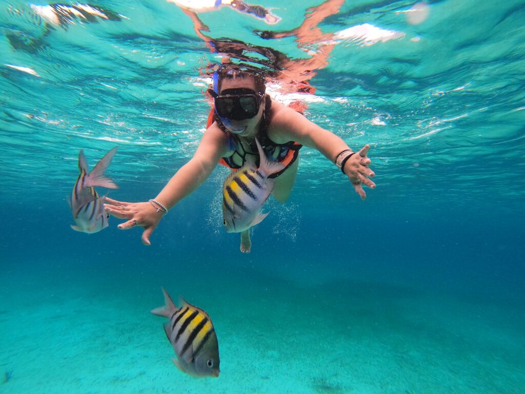 pexels photo 18834847 18834847 Woman snorkeling with vibrant tropical fish in Cozumel's clear blue waters.