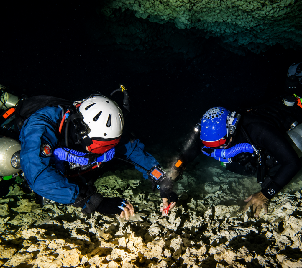 Deux élèves en formation CCR Cave réalisent un exercice avec black mask en recherchant la ligne de vie pour retrouver la sortie en visibilité nulle.
