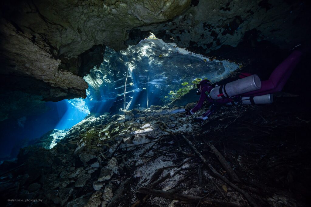 Plongée en cénote au Cenote Nicte Ha avec rayons de lumière et formations calcaires près de Tulum, Mexique